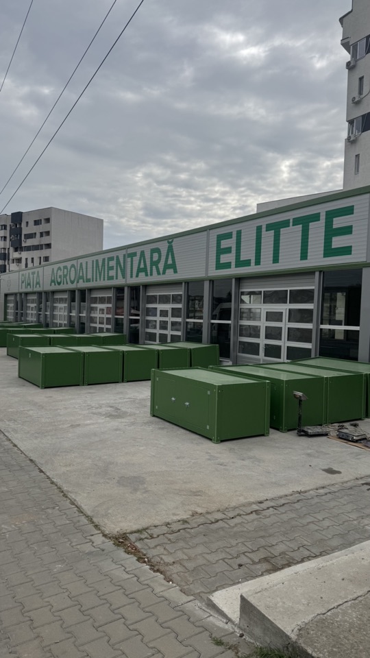 Tarabe metalice verzi așezate pe platforma betonată din fața Pieței Elitte